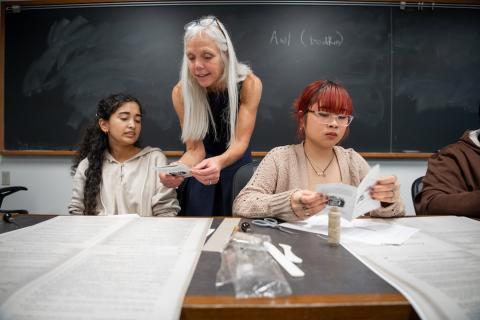 Students learn how to bind books in a classroom.