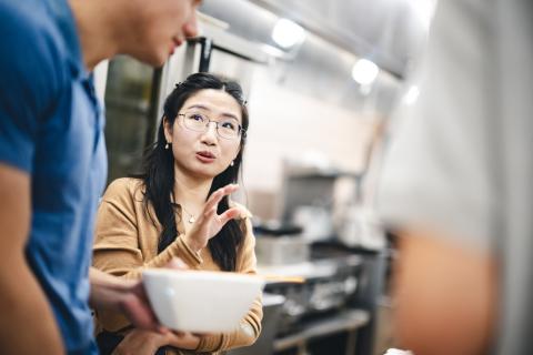 Wandi Wang talks to her class in a kitchen for a food lab.