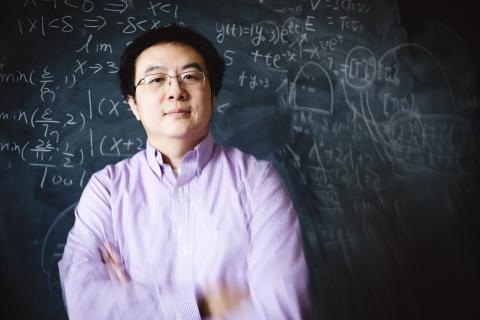 Xianyi Zeng portrait in front of a chalk board.