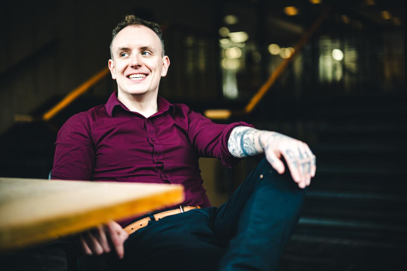 Daniel Laverty sits at a table for a portrait.